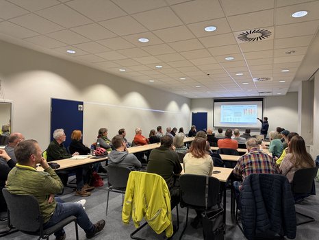 Die Teilnehmenden des Beteiligungsworkshops lauschen in einem Besprechungsraum einer Präsentation zum Radverkehrskonzept