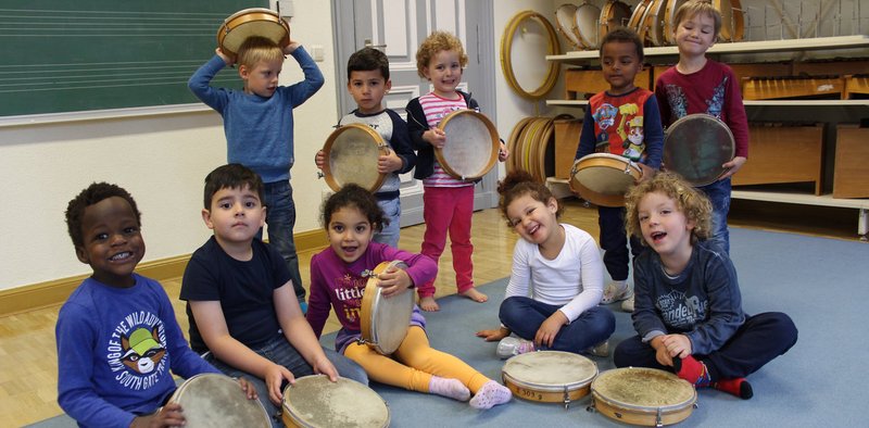 Eine Gruppe kleiner Kinder mit Tamburinen