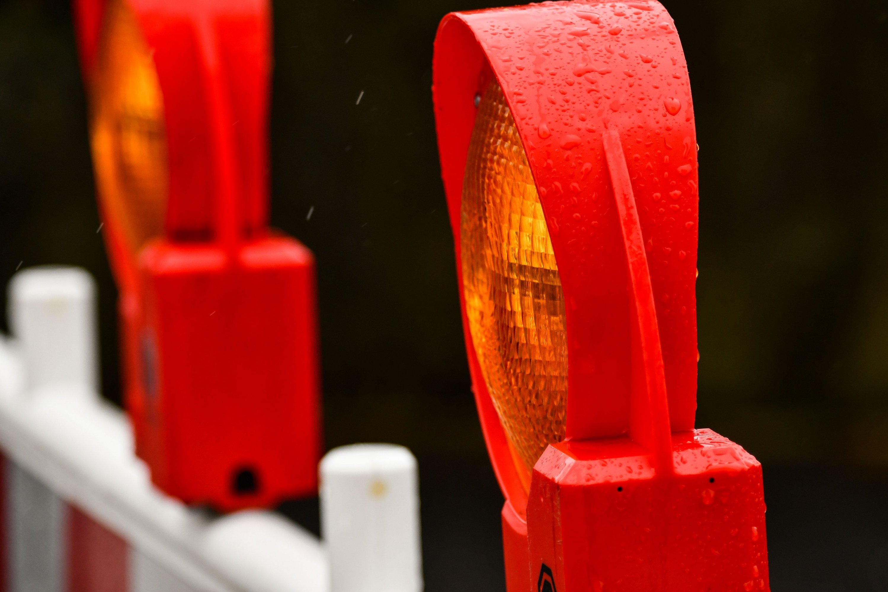 Ein Warnleuchte auf einer Baustellenabsperrung in Großaufnahme, im Hintergrund eine weitere Leuchte.