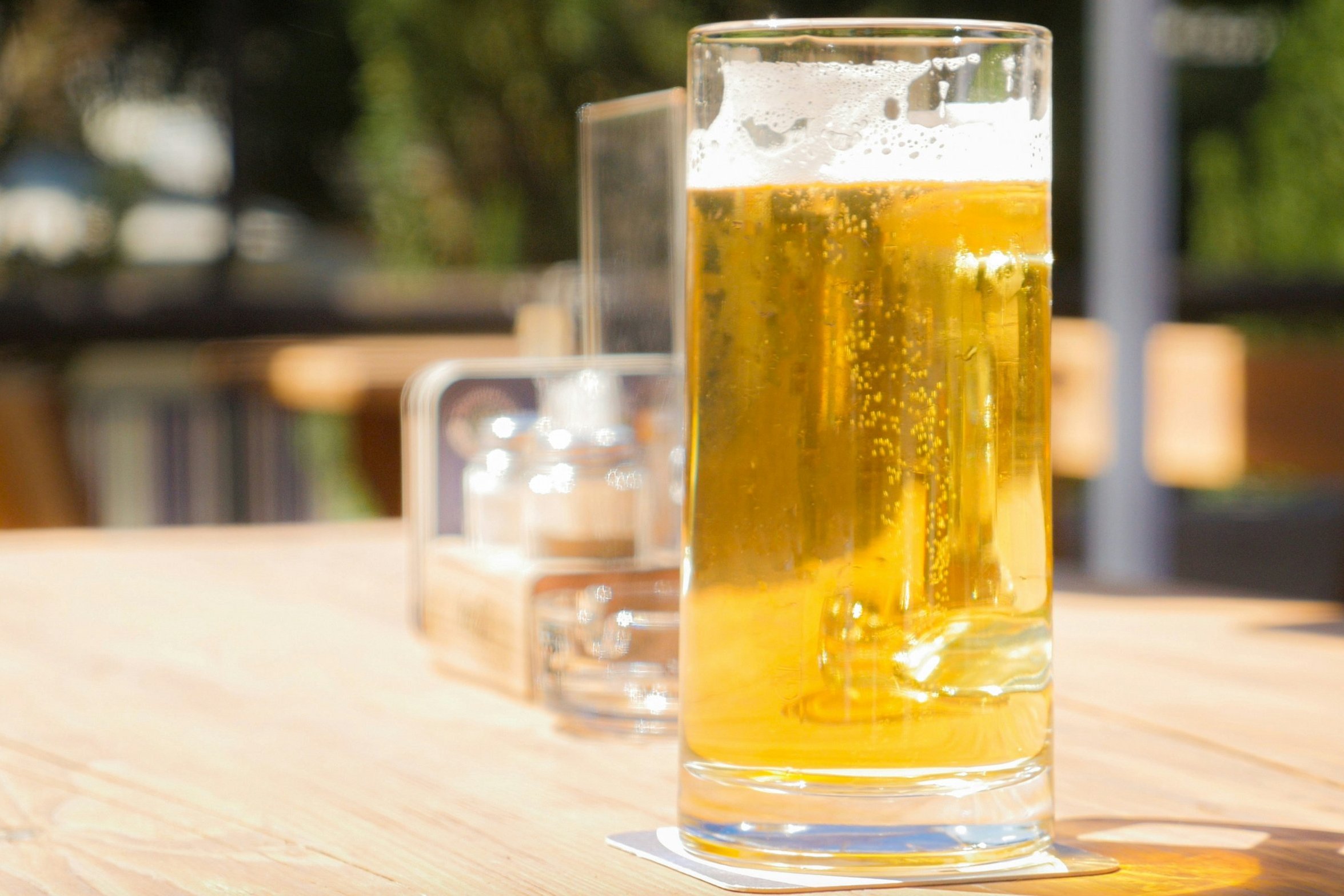 Ein Bierglas steht im Außenbereich eines Restaurants auf einem Tisch.