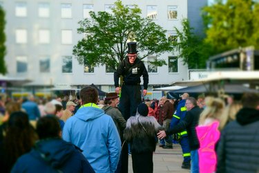 Stelzenläufer inmitten einer Menschenmenge auf dem Stadtfest