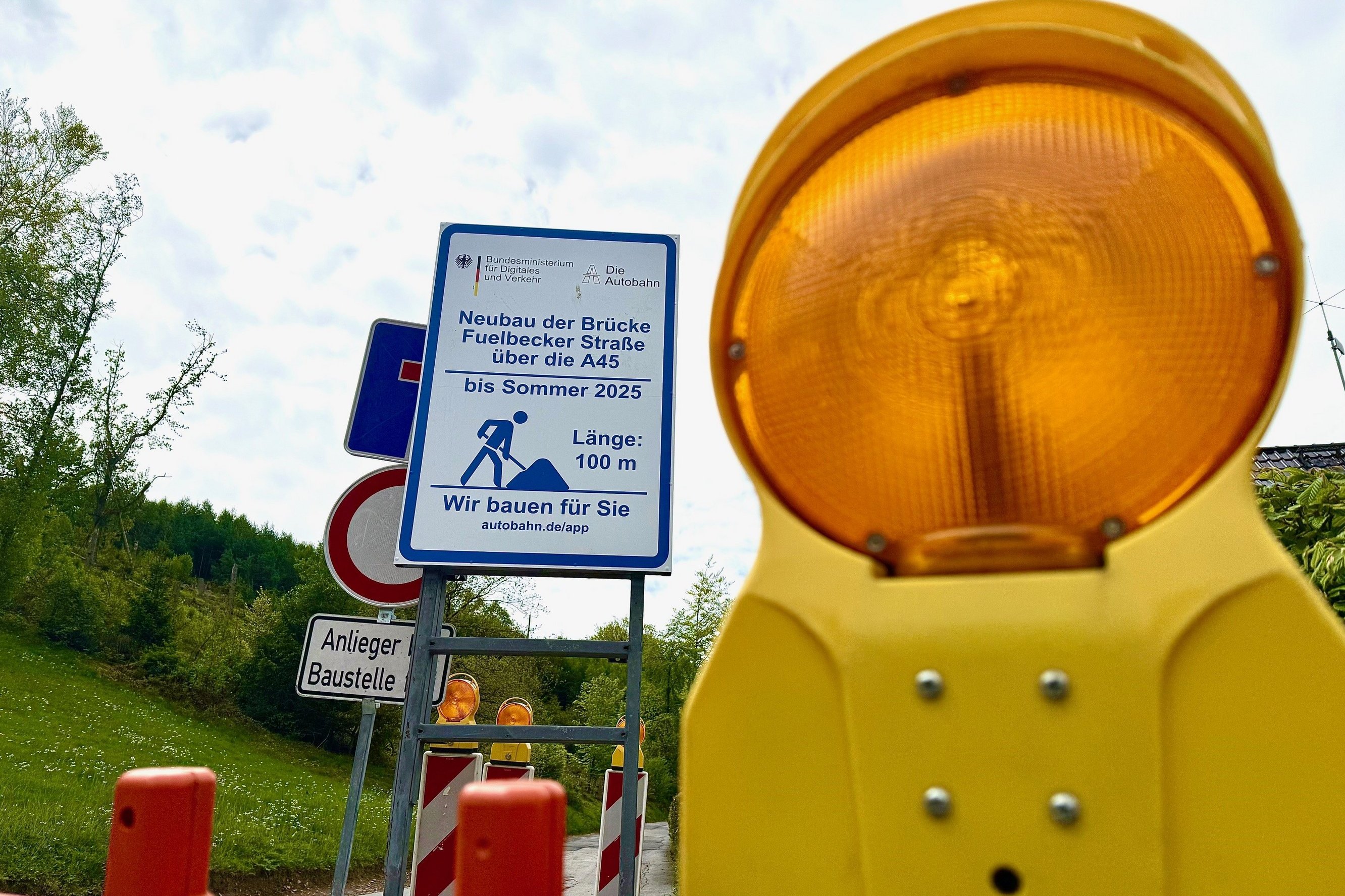 Eine Baustellenabsperrung und ein Hinweisschild.