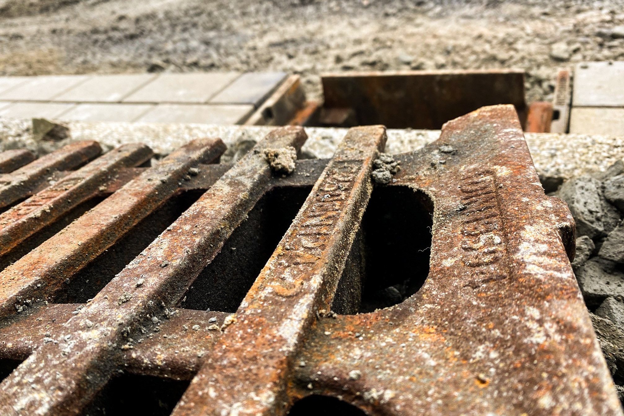 Geöffneter Kanalschacht, davor liegt ein Kanaldeckel