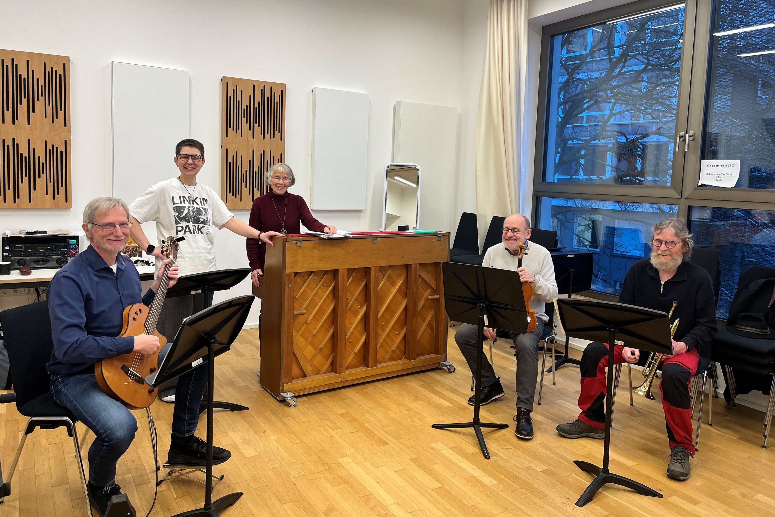 Fünf Musiker haben sich mit Musikinstrumenten zu einem Gruppenfoto zusammengestellt.