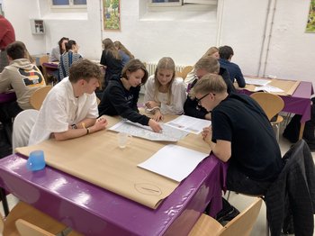 Jugendliche tauschen sich am Gruppentisch zur Mobilität in ihrer Stadt aus