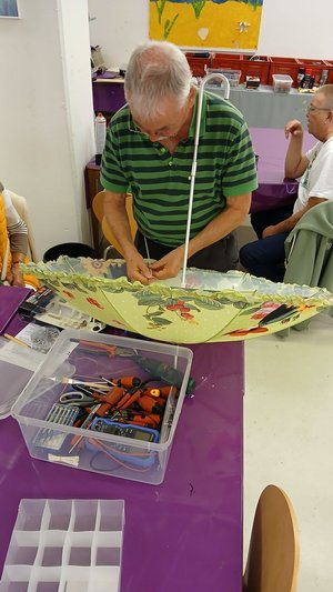 Ein Mann repariert im Reparaturcafé der Stadtbücherei einen Schirm