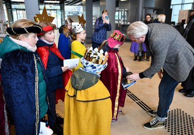 Bürgermeister Sebastian Wagemeyer füllt die Spendendose der Sternsinger