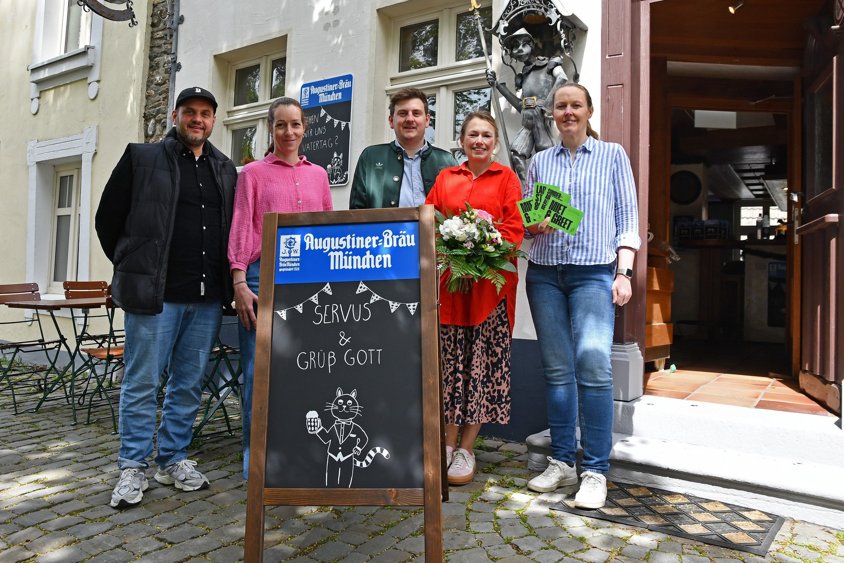 Gruppenbild vor dem neuen Lokal Kater August am Kirchplatz
