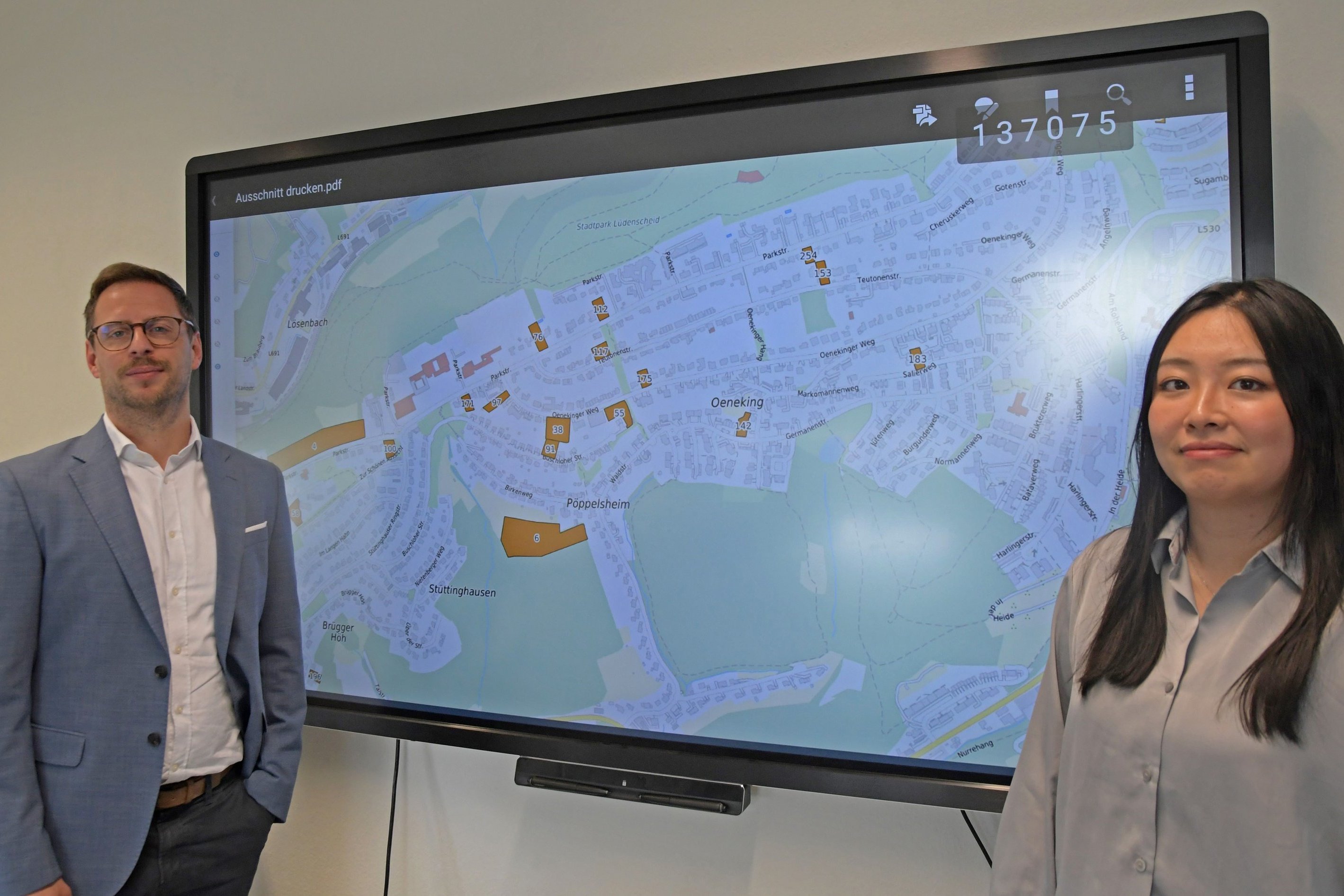 Zwei Mitarbeiter der Stadt präsentieren das Baulandkataster