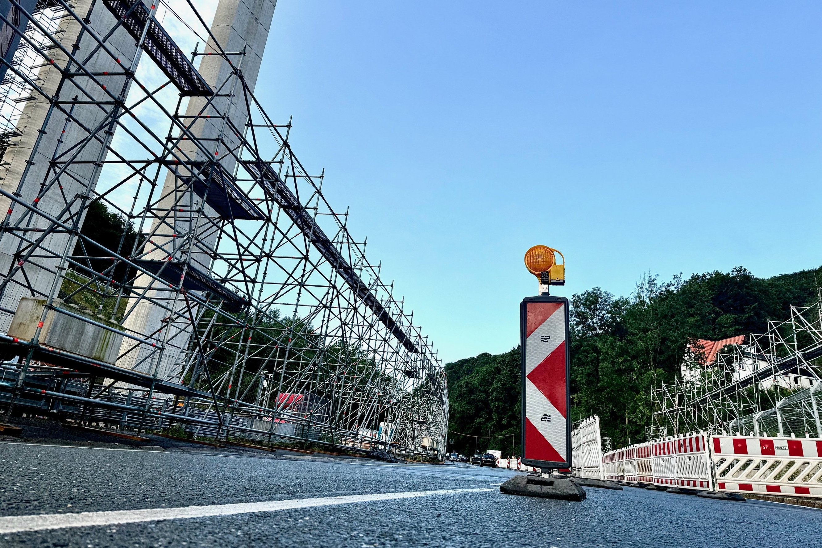 Auf der Altenaer Straße stehen Absperrungen. Links ist ein großes Stahlgerüst zu sehen.