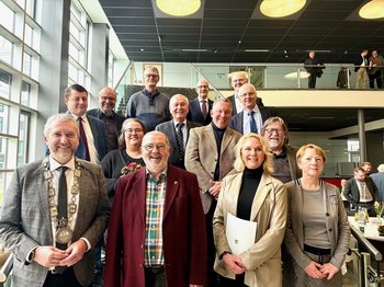 Gruppenfoto auf der Treppe im Rathaus-Foyer: Bürgermeister Sebastian Wagemeyer (vorne links) verabschiedete die langjährigen Ratsmitglieder.