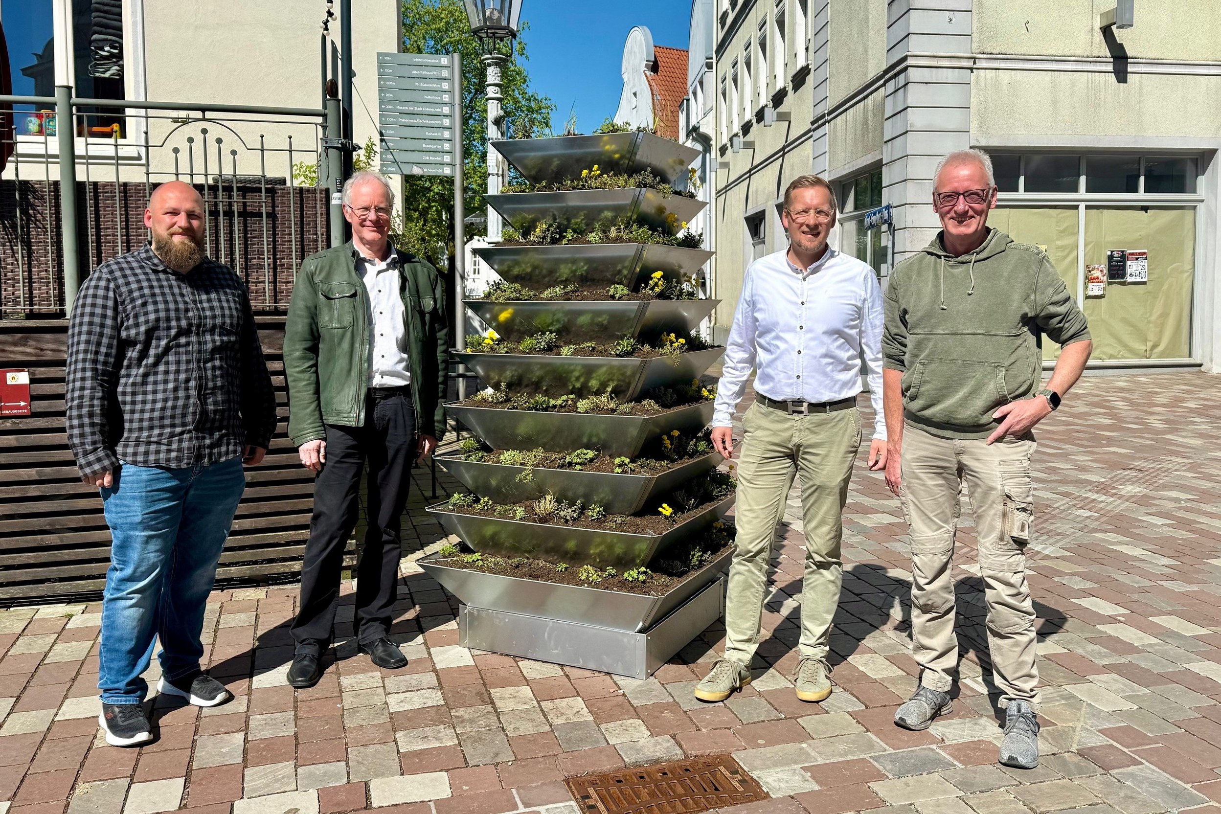 Präsentierten die Blumen-Pyramide in der Oberstadt und stellten sich für ein Gruppenfoto daneben auf: (von links) Florian Sommer, Andreas Fritz (beide STL), Ole Marzulla (Maurmann Garten- und Landschaftsbau GmbH) und Dirk Müller (Gärtnerei Heinz Kissing). Foto: Sven Helmig