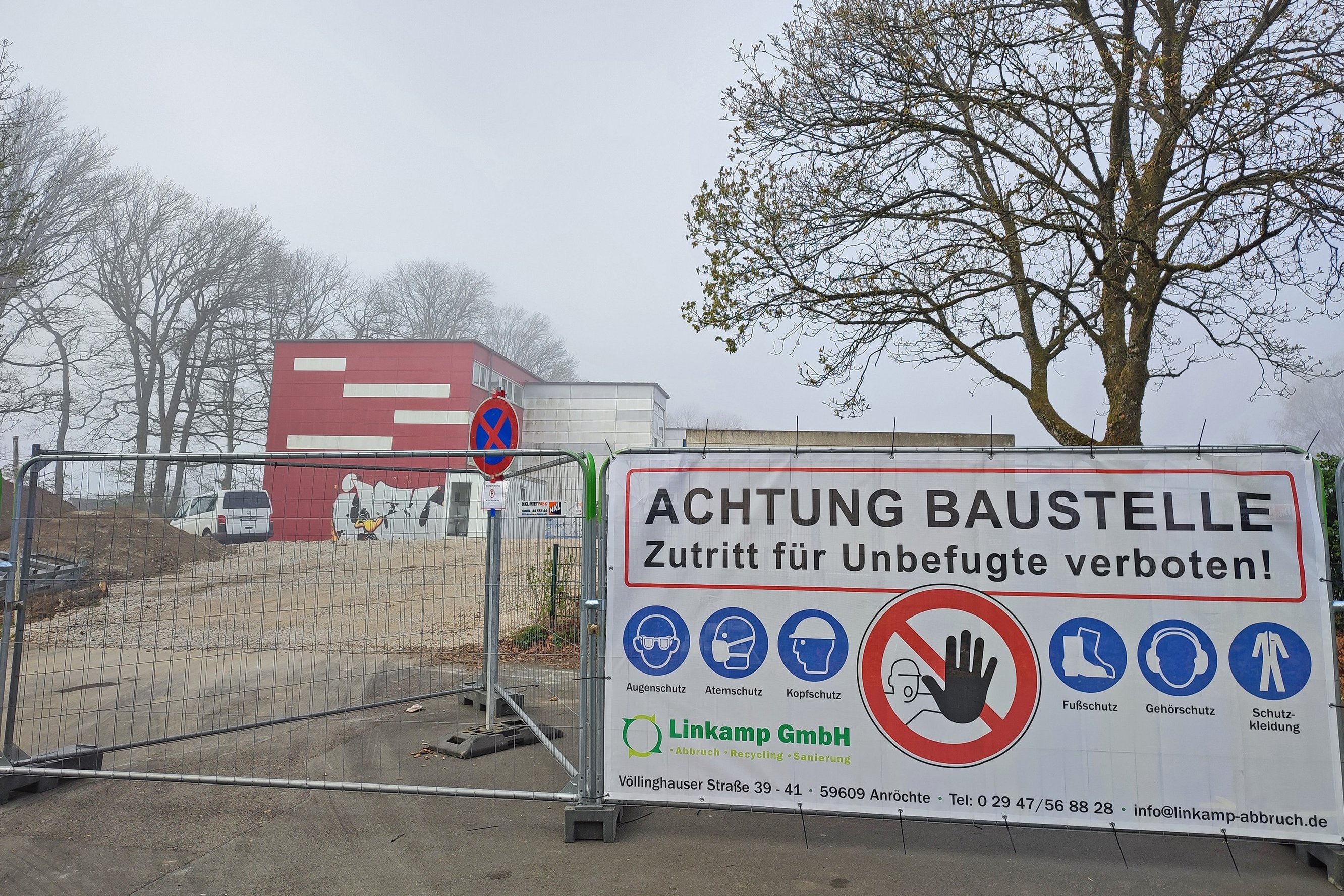 Ein Banner mit "Achtung Baustelle" vor dem abgesperrten Gelände der Grundschule Lösenbach.