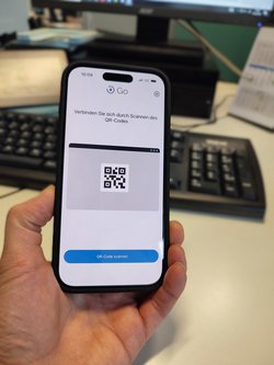 Ein Handgerät im Handyformat, auf dem ein QR-Code zu sehen ist.
