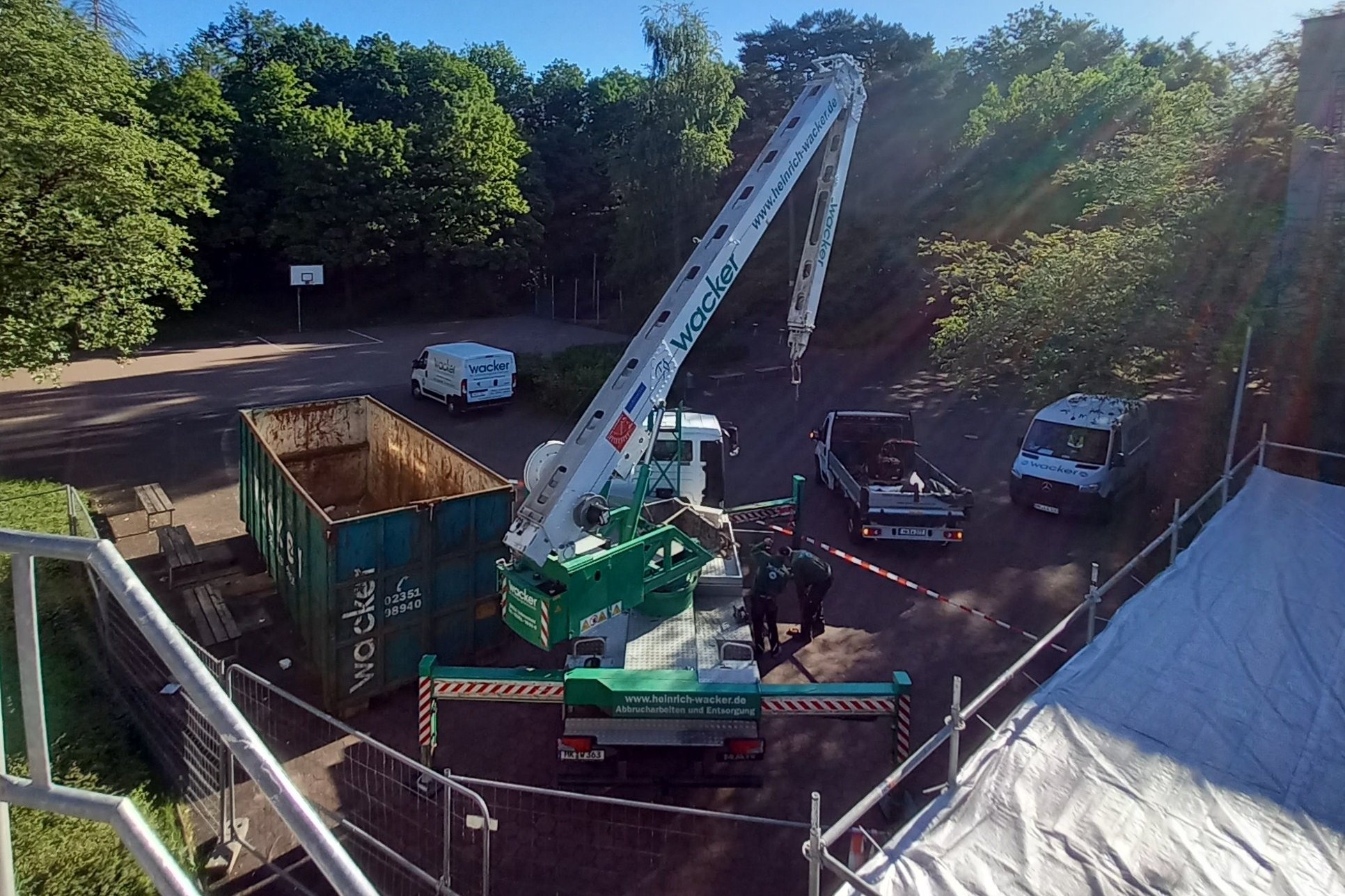 Ein kleiner Teil des Schulhofes ist abgesperrt, damit der Lkw-Ladekran Materialien vom und auf das Dach der Theodor-Heuss-Realschule transportieren kann. 