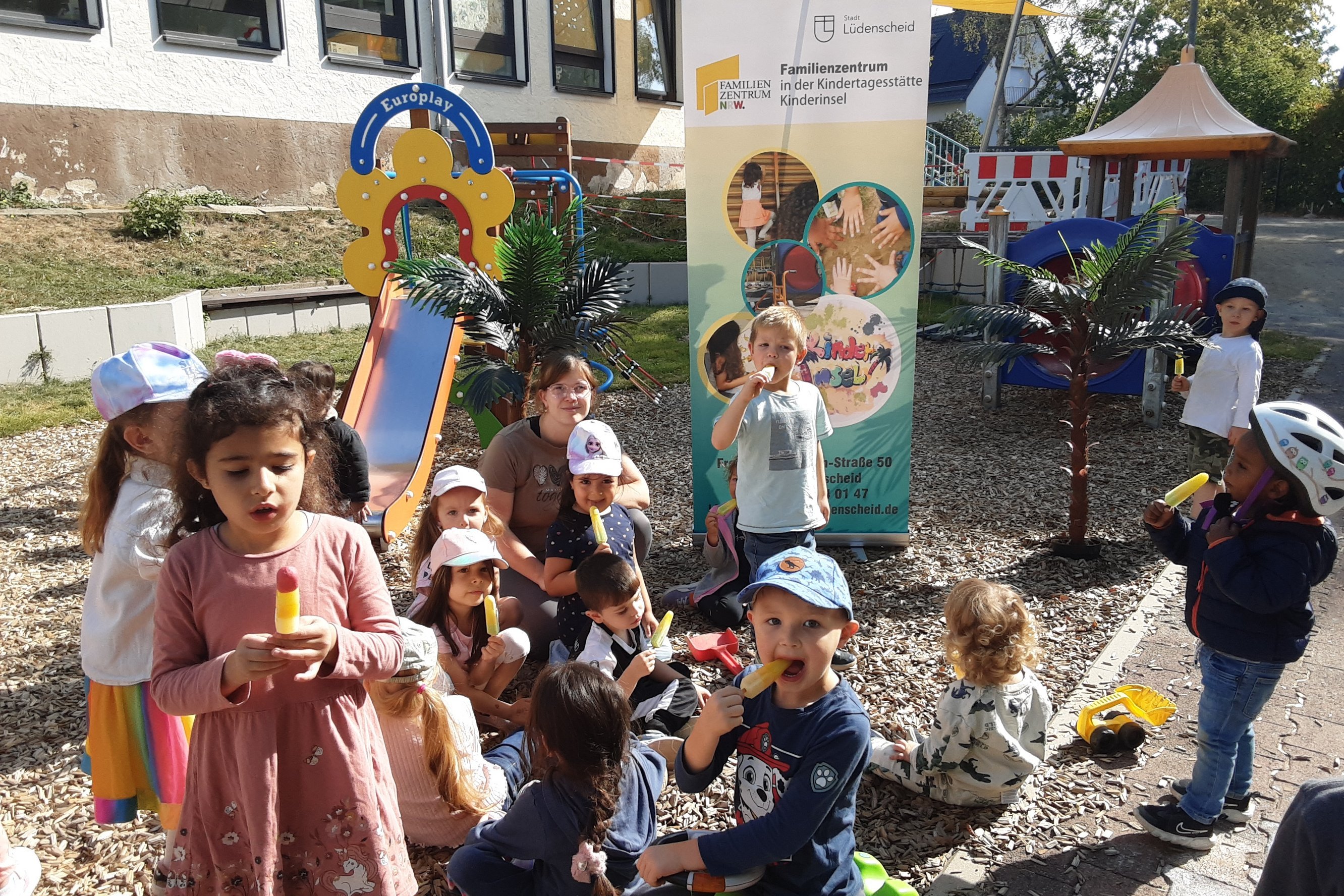 Mehrere Kita-Kinder grinsen mit einem Eis in der Hand in die Kamera.