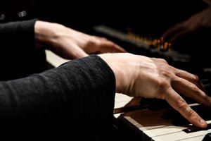 Die Hände eines Pianisten beim Klavierspielen