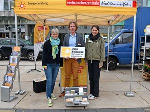 Vertreter der Verbraucherzentrale und der Stadt Lüdenscheid an einem Aktionsstand auf dem Wochenmarkt