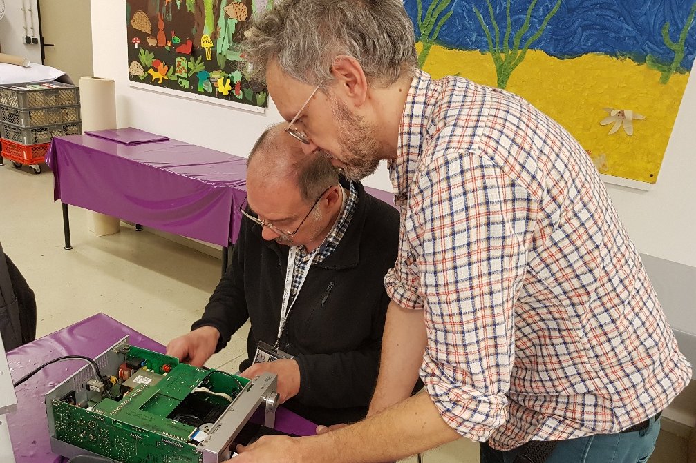 Zwei Männer reparieren einen Gegenstand im Reparaturcafé in der Statdbücherei