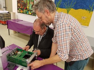 Zwei Männer reparieren einen Gegenstand im Reparaturcafé in der Statdbücherei