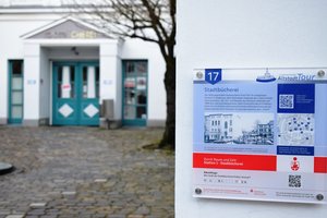 Hinweistafel an der Fassade der Stadtbücherei mit QR-Code für weitere Infos