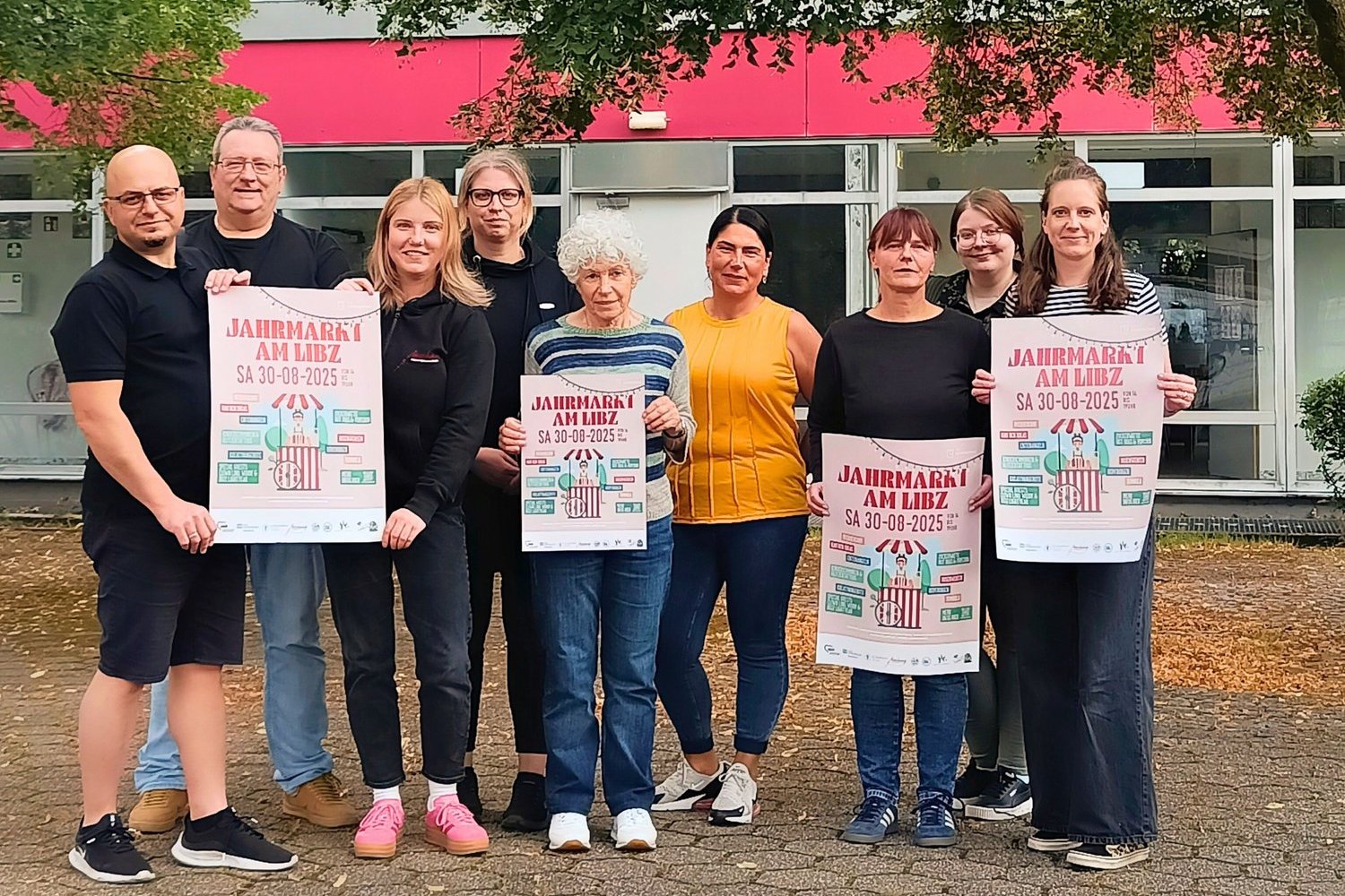 Gruppenfoto einiger Akteure mit Plakaten, die den Jahrmarkt am LIBZ organisieren