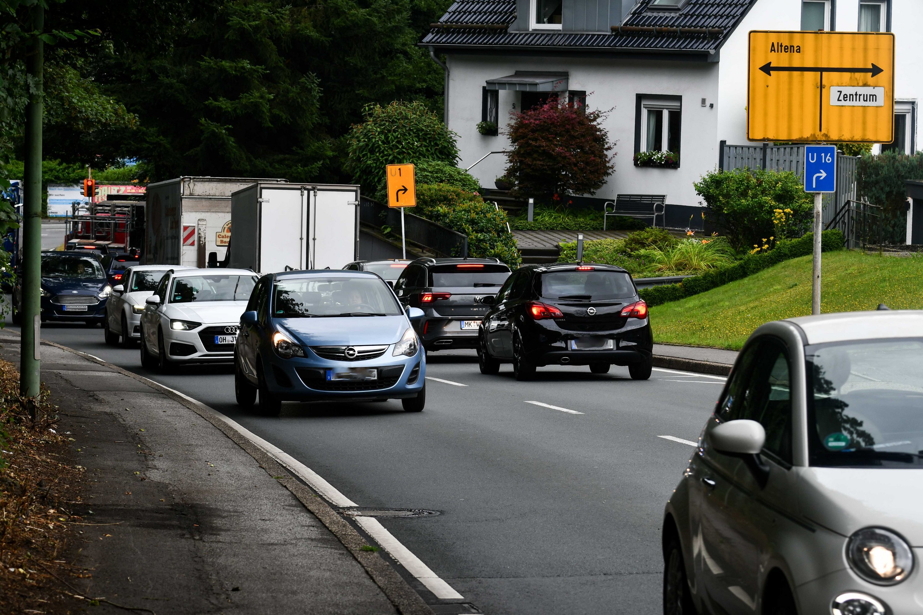 Autos und Lkw befahren die Straße "Im Grund". 