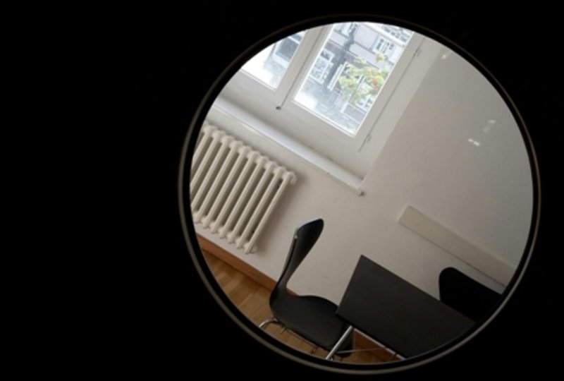 Ein Blick in den Arbeitsraum durch das Bullaugen-Fenster der Tür