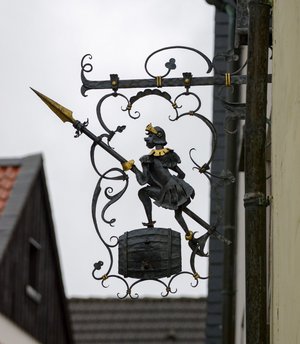 Metallschild mit bewaffneter Figur an einer Hauswand in der Altstadt