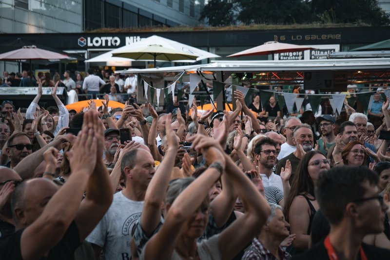 Besucher eines Konzerts klatschen.