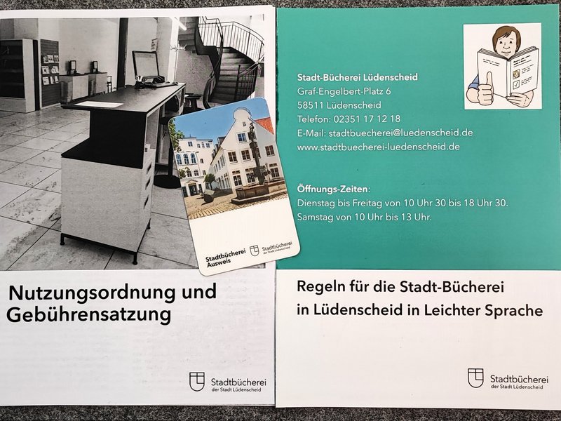 Ein Stadtbücherei-Ausweis liergt auf der Nutzungsordnung