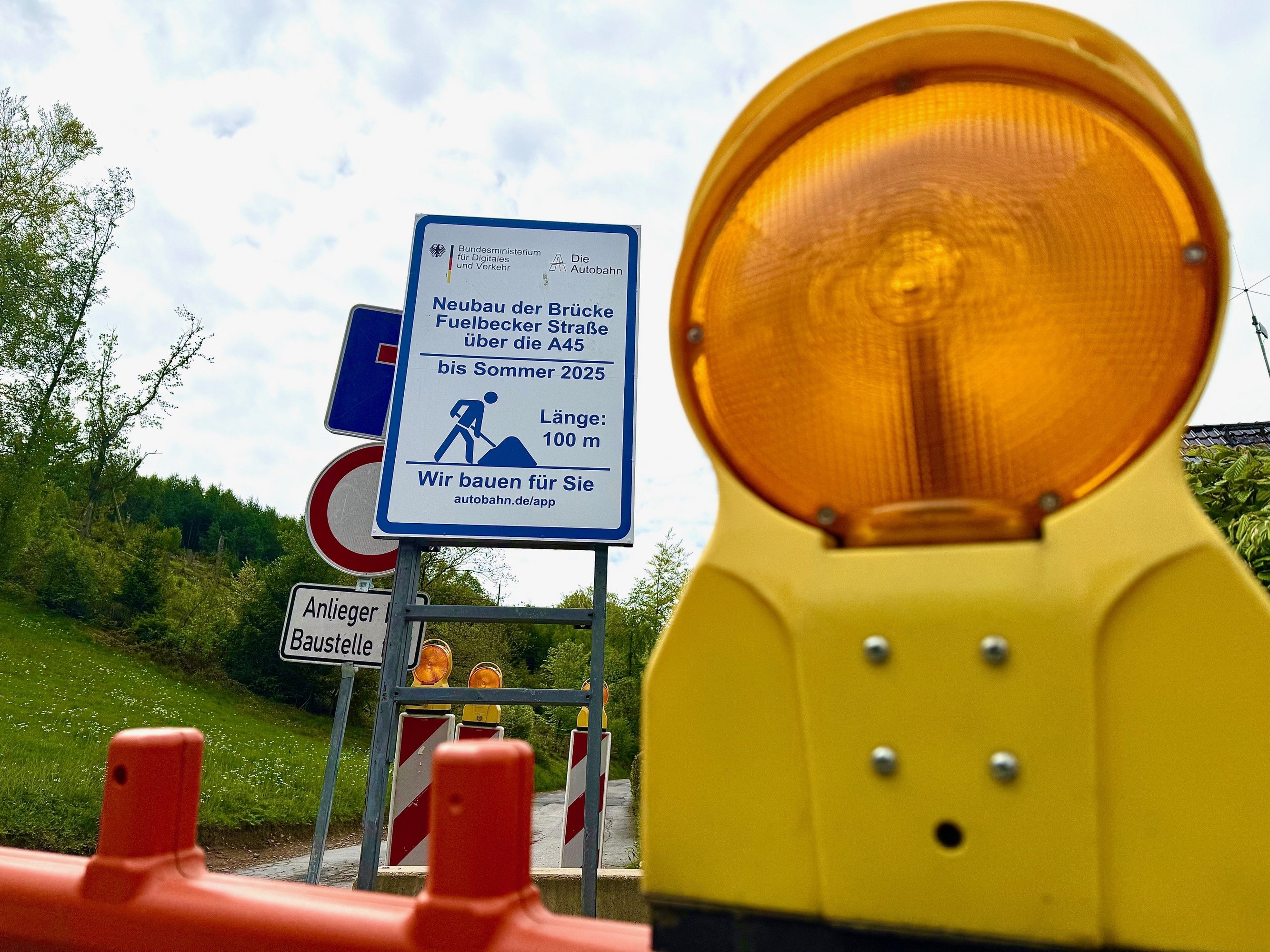 Eine Baustellenabsperrung und ein Hinweisschild.
