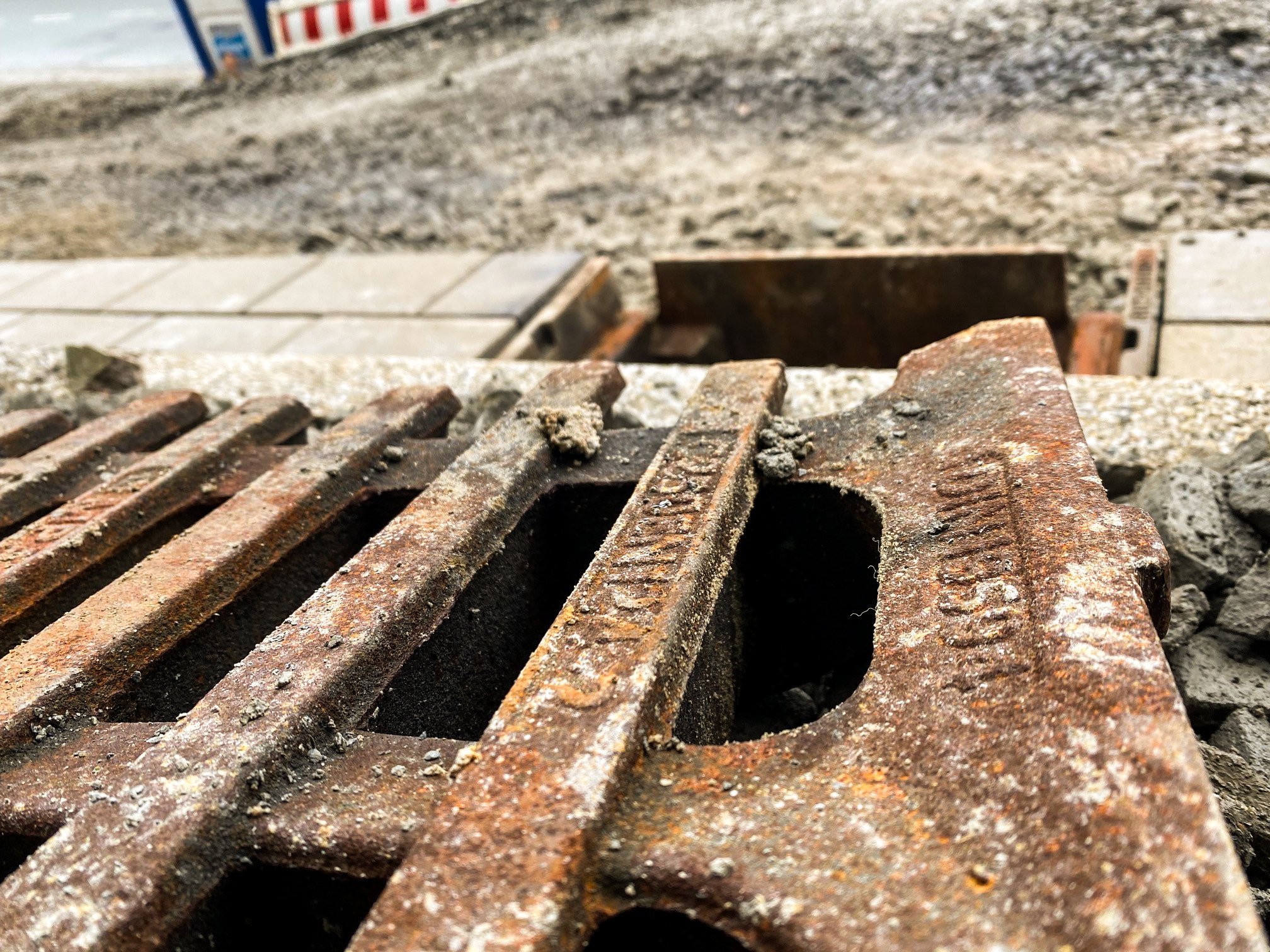 Geöffneter Kanalschacht, davor liegt ein Kanaldeckel