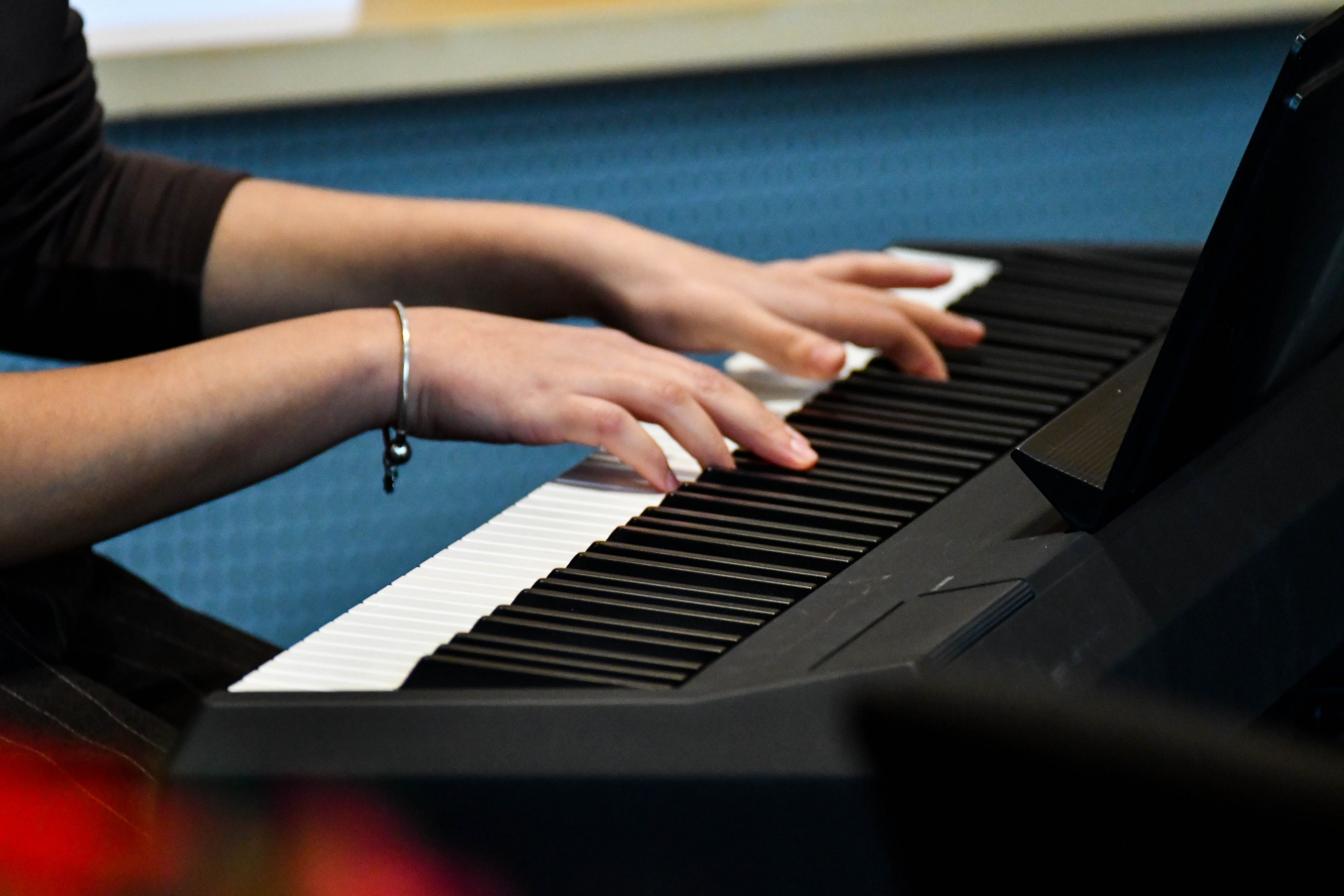 Nahaufnahme von Händen, die auf einem Piano spielen 